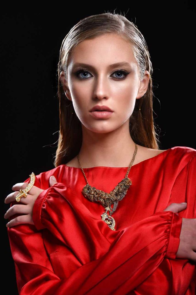 model in a red shirt with a necklace