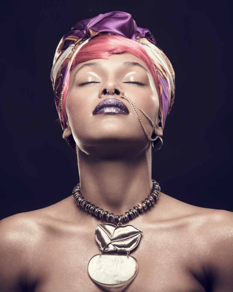 model with a large necklace from a fashion production